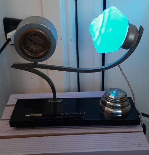 Immagine di Particolare lampada , calamaio e orologio Liberty Base in vetro nero .